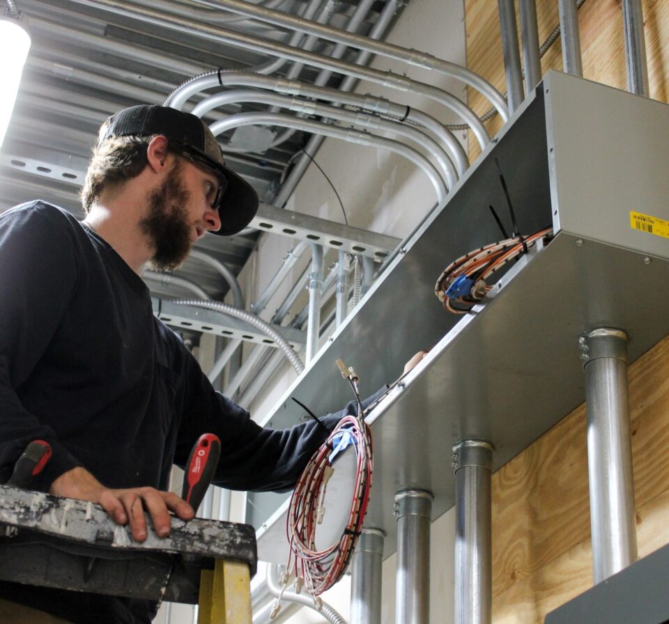 Contractor installing electrical wiring in commercial building for power distribution