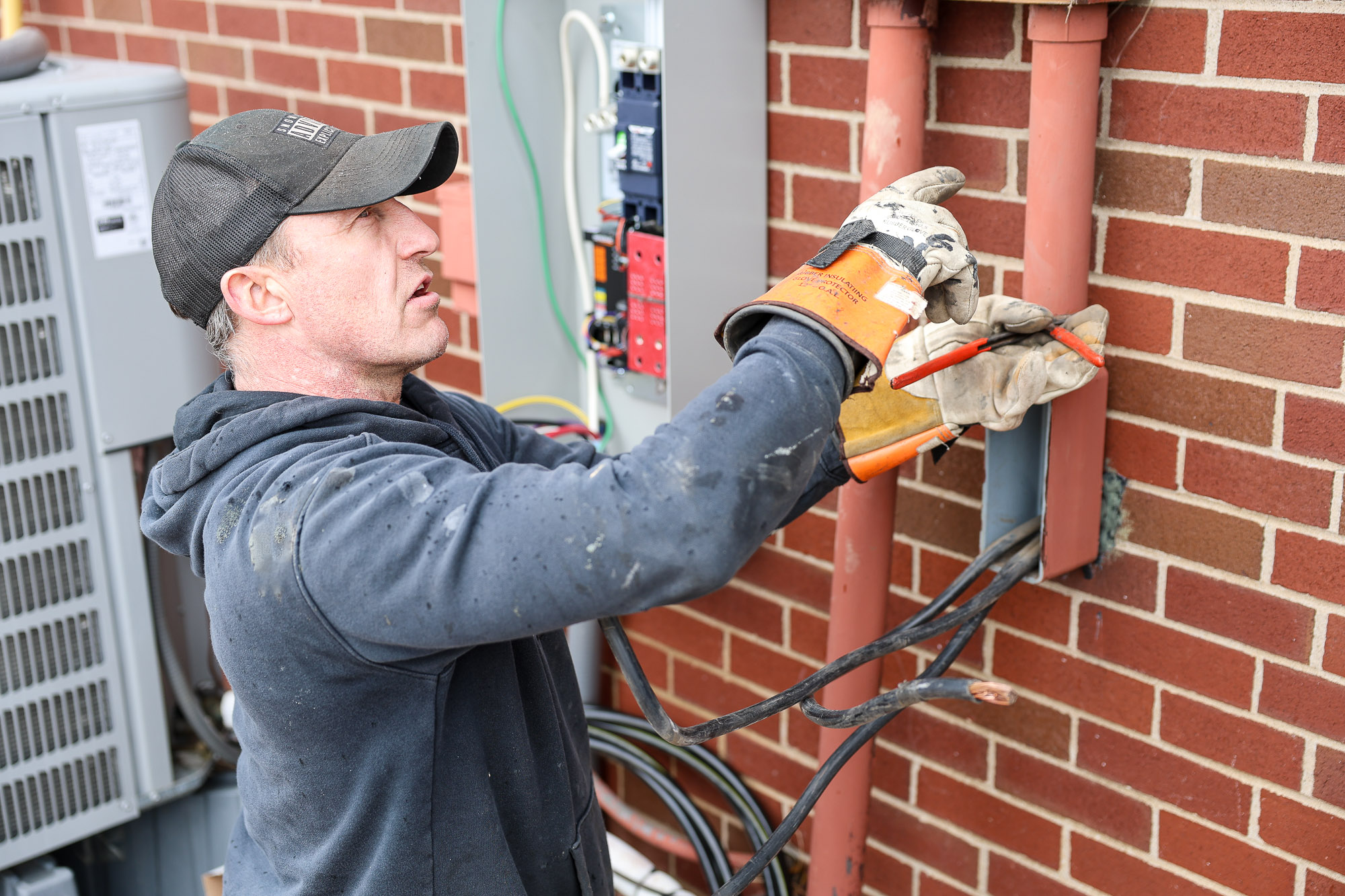 Professional electrician running outdoor electrical wiring showcasing expert craftsmanship and commitment to construction safety